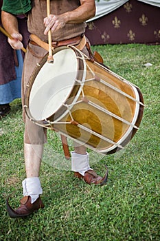 Bass drum player in medieval costume performing at an historic r