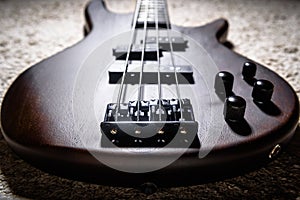 Bass electric guitar with four strings closeup. Detail of popular rock musical instrument. Close view of bass, focus on bridge