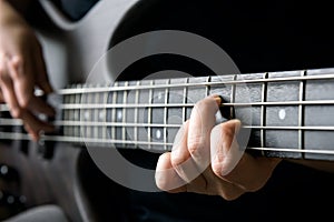 Bass guitar player hand closeup, lesson and practice theme. Playing on bass electric guitar, live music and skill concept