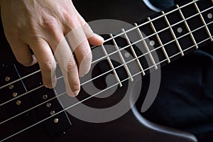 Bass guitar player hand closeup, lesson and practice theme. Playing on bass electric guitar, live music and skill concept