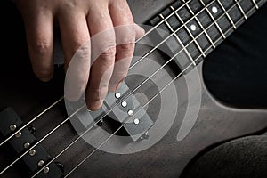 Bass guitar player hand closeup, lesson and practice theme. Playing rock on bass electric guitar, live music and skill concept