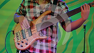 Bass guitar player on stage of ethnic open air concert