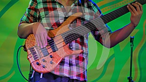 Bass guitar player on stage of ethnic open air concert