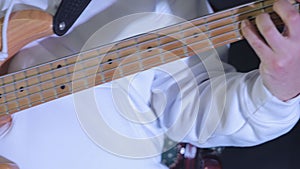 Bass Guitarist's Hand in Action, Close-up of a bass guitarist's hand plucking the strings, details of the
