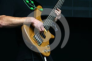 Bass player hands with five string bass guitar