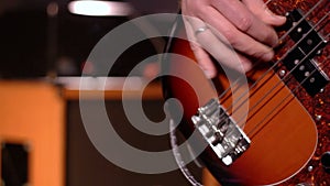 Bassist. Defocus on a male hand playing bass