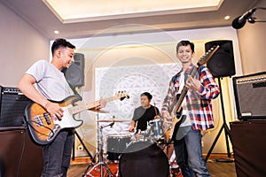 a bassist, guitarist and drummer as a band playing songs