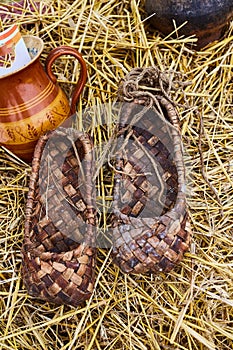 Bast shoes on the straw at the souvenir market. Traditional shoes in Russia