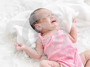 A bastard newborn baby crying in bed Because she was hungry and sick photo