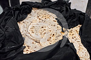 Batch of chapati round flatbreads in black bag for langar in sikh gurudwara temple, roti flatbreads