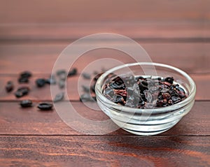 Batch of dry barberries on the background of dark boards