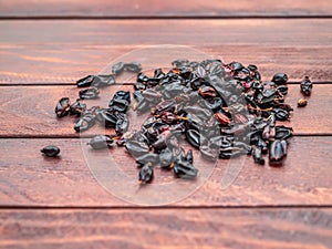 Batch of dry barberries on the background of dark boards