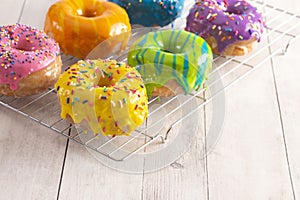 A Batch of Rainbow Donuts on a White Wood Table