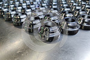 A batch of shiny metal cnc aerospace parts production - close-up with selective focus for industrial background