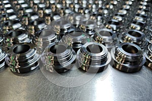 A batch of shiny metal cnc aerospace parts production - close-up with selective focus for industrial background