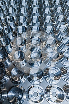 A batch of shiny metal cnc aerospace parts production - close-up in selective focus for industrial full frame background