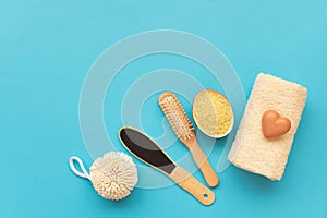 Bath accessories: towel, salt, brush, wisp, pumice and soap on blue background. Spa cosmetic or hygiene concept. Copy space. Flat