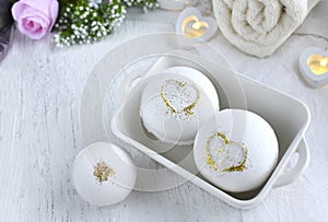 Bath aroma bombs set with heart,  towel on white background.