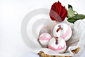 Bath bombs,in basket and red rose on white background.