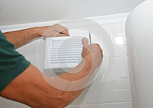 Bath fan repair, installation. Handyman installing new bath vent fan, ventilation system in the house bathroom