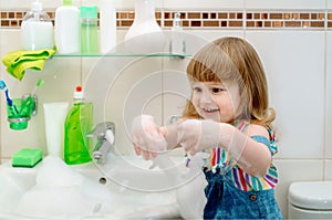 bath foam baby.Cleaning the bathroom. Foam in the washbasin, green soap,green gloves in the girl. Clean house. cleaning