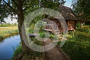 Bath house on the shore of the pond in summer