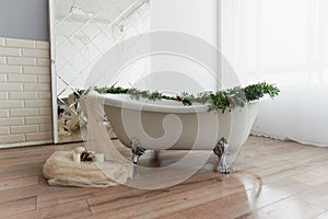 Bath on lion`s paws, decorated with flowers. On the floor are candles.A romantic setting for a date