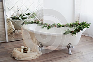 Bath on lion`s paws, decorated with flowers. On the floor are candles.A romantic setting for a date