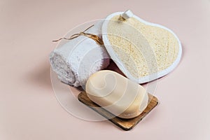 Bath loofah, towel and soap on a colored background