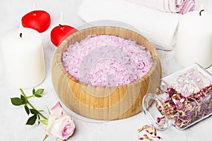 Bath salt with aroma of a rose in a wooden bowl, petals and a fr