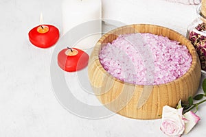 Bath salt with aroma of a rose in a wooden bowl, petals and a fr