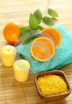 Bath salt in wooden bowl, towel, candle and fresh