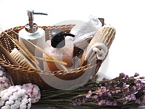 Bath set in the basket with flower decoration on white background