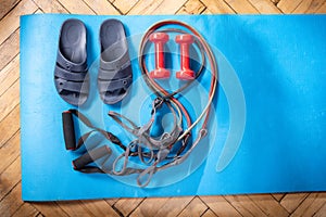 Bath slippers and fitness dumbbells. Fitness dumbbells and rubber expanders. Fitness workout at home