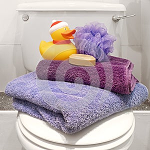 Bath towels, soap and duck in bathroom.