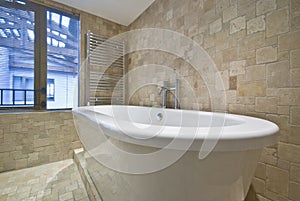 Bath tub detail with stone tiled walls