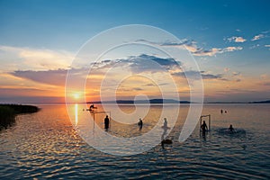 Bather`s silhouettes at sunset in Lake Balaton, Hungary