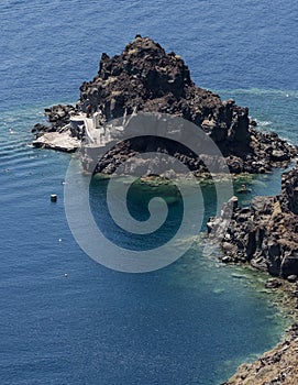 Bathers in sea off small island at Oia, Santorini