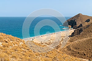 Bathers sunbathing on Los Muertos beach, Carboneras, Almeria, Spain.