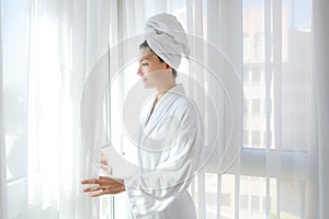 Bathrobe woman sunny window white curtains photo