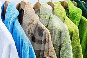 Bathrobes of different colors hang on a hanger