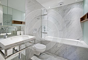 Moderno bagno con vasca, wc e lavandino con luce di marmo fine.