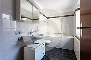 Bathroom with black tiles and large bathtub