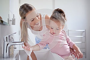 Bathroom, clean and washing hands with child and mother teaching hygiene with running tap water in basin. Family, health