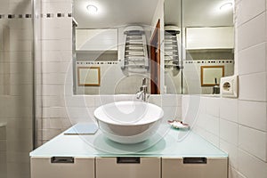 Bathroom with concave white porcelain sink, glass top and