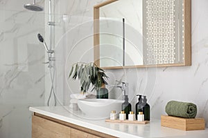 Bathroom counter with stylish vessel sink and toiletries. Interior design