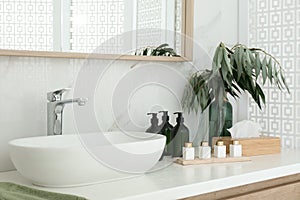 Bathroom counter with stylish vessel sink and toiletries. Interior design