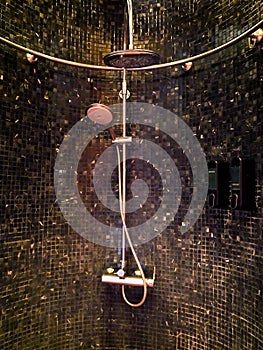 Bathroom decoration in the shower area with shower on black tiles