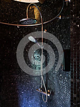 Bathroom decoration in the shower area with shower on black tiles