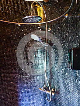 Bathroom decoration in the shower area with shower on black tiles